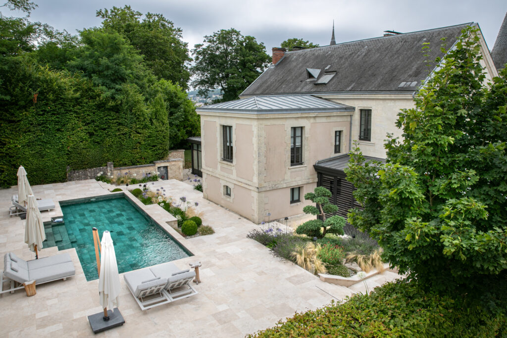 Aménagement piscine haut de gamme avec dallage en pierre et jardin paysager signé Franck Serra en Dordogne